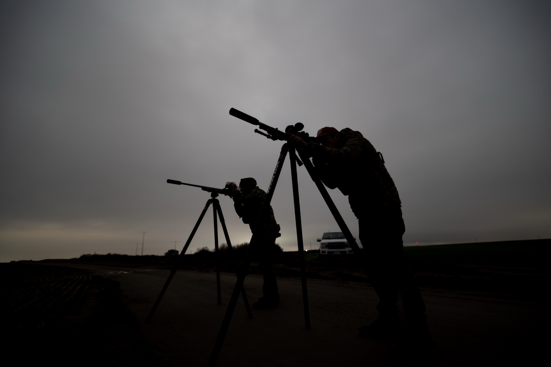 Two shooters silhouetted on tripods at first light
